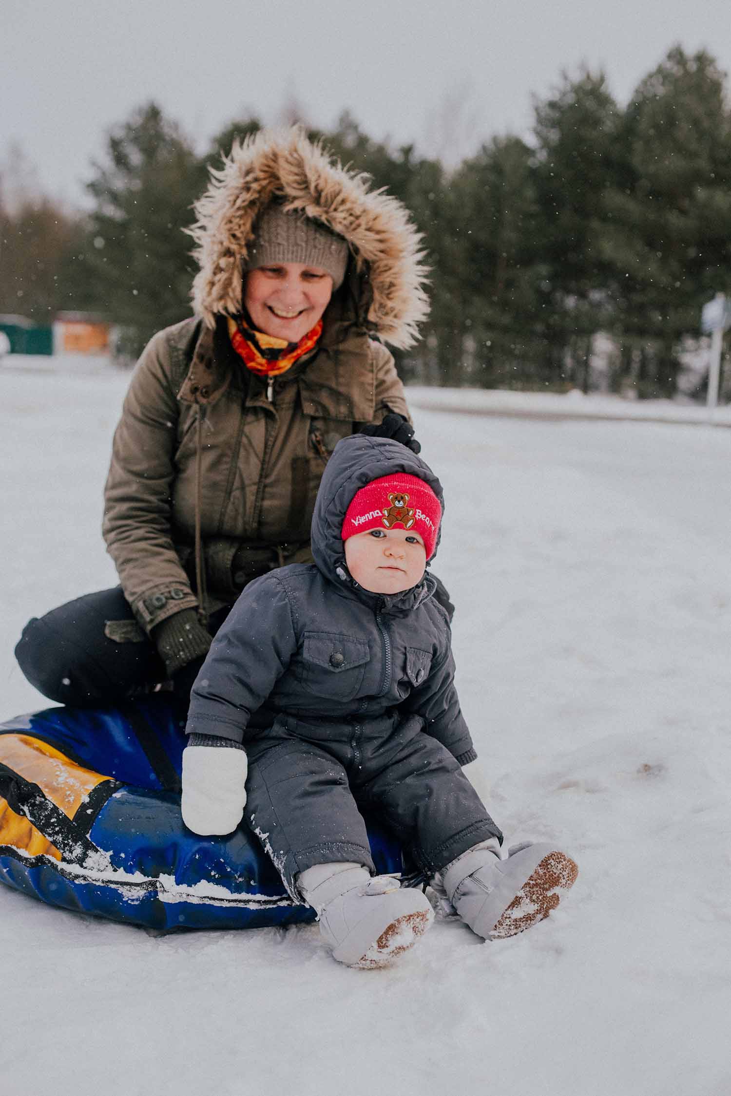 a person and a child on a tubing in the snow